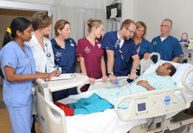 A clinical team gathered around a patient who had tracheostomy