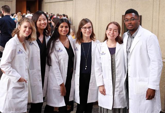 Vondel Mahon, Alisa Brandt, Brittany Bennett, Lohitha Kethu, Insil Choi and Cecelia Johnson, wearing their white coats. Photo credit: Gene Chung.