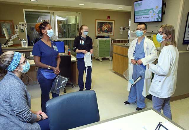 Providers discussing while wearing masks.